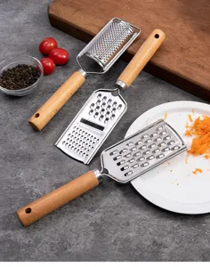 Stainless steel kitchen grater detail showing sharp blade holes and comfortable wooden handle.