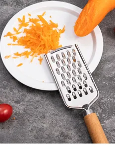Stainless steel kitchen grater with wooden handle, perfect for shredding carrots and vegetables.