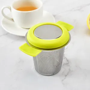 Stainless steel tea infuser with green silicone lid and double handles for loose leaf tea.