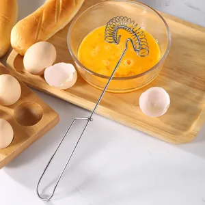Stainless steel manual spring egg whisk kitchen tool for home baking and cream mixing.