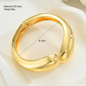 Vista detallada del brazalete geométrico dorado con medida de diámetro de 6,1 cm.