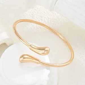Detalle de cerca de un brazalete ajustable de metal dorado con estilo de lava