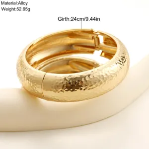 Vista detallada de la textura martillada de un brazalete ancho dorado, 24 cm de contorno