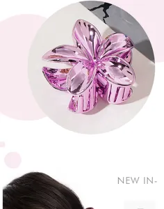 Detail view showing the metallic texture of a purple frangipani flower hair claw clip
