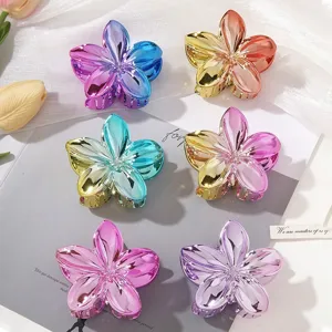 Macro view showing set of glossy metallic Frangipani hair claw clips with gradient colors