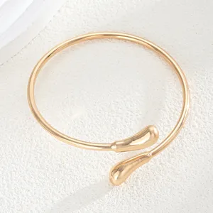 Primer plano detallado del brazalete de metal dorado estilo lava con puntas de gota