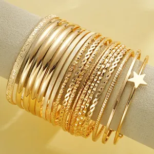Detailed close-up of 18-piece gold bangle set featuring star charm and twisted textures.