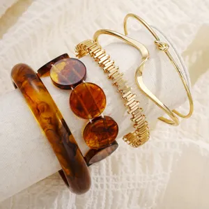 Dettaglio ravvicinato di un elegante set di bracciali in metallo dorato e resina tartarugata