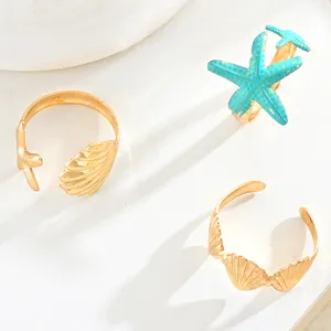Detailansicht eines 3-teiligen goldenen Ring-Sets mit Seestern- und Muschelmotiven