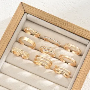 Detalle de un conjunto de 9 anillos ajustables dorados para dedos del pie con strass.