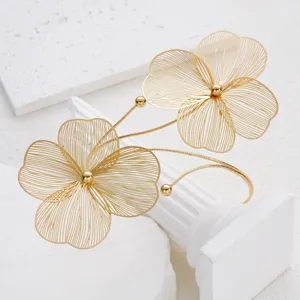 Detail view of golden filigree hollow flower anklet with 3D floral design