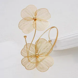 Close-up detail of the intricate hollow filigree flower design on a golden anklet