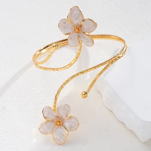 Vista dettagliata di un elegante bracciale da braccio regolabile con fiori in smalto bianco
