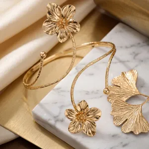 Dettaglio di eleganti bracciali da braccio dorati regolabili con decoro floreale