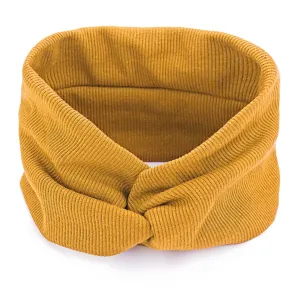 Primer plano detallado de la diadema de punto trenzada amarillo mostaza con nervaduras