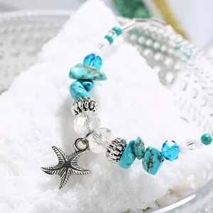 Close-up detail of vintage starfish pendant and turquoise beads on beach anklet