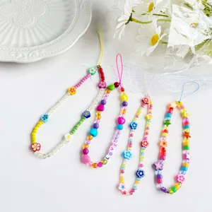 Close-up of colorful polymer clay beaded phone lanyards with flower and heart charms