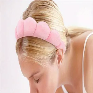 Plush pink sponge headband for skincare and makeup routines on a female model