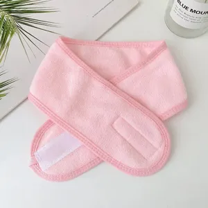 Detailed macro view of a soft pink spa headband with an adjustable white velcro closure
