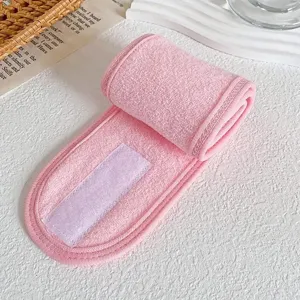Close-up detail of soft pink spa headband with adjustable Velcro closure for skincare.