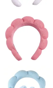 Close-up detail showing the soft plush texture of pink and blue puffy spa headbands