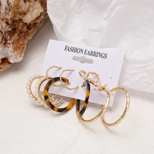 Detalle de set de 5 pares de pendientes de aro en acrílico, metal dorado y perlas