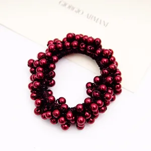 Vue détaillée d'un chouchou à perles rouges brillantes avec une texture très élégante.