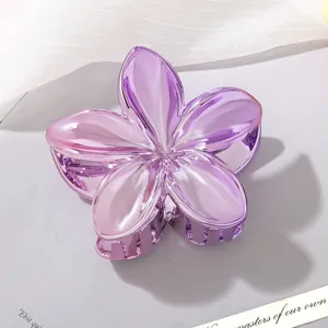 Detail view of metallic purple Plumeria flower hair claw clip with shiny glossy finish