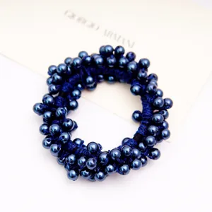 Gros plan d'un chouchou à perles bleu marine pour accessoires de cheveux