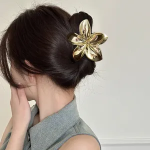 Glossy metallic gold plumeria flower hair claw clip for elegant bun hairstyles in summer