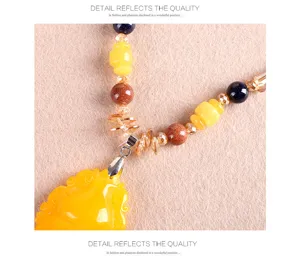 Détail du collier ethnique vintage avec pendentif en ambre et perles de cristal colorées