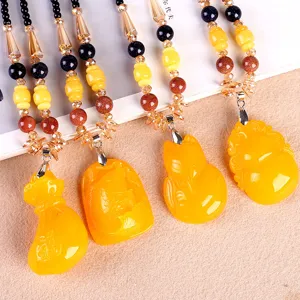 Sautoir ethnique fait main avec pendentifs en ambre synthétique jaune aux formes variées