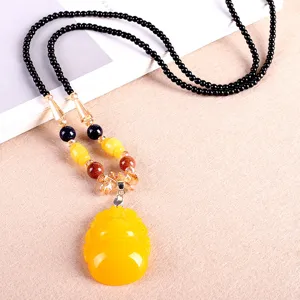 Sautoir ethnique vintage avec grand pendentif bouddha en ambre synthétique jaune