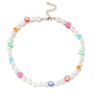 Vue rapprochée d'un collier de perles blanches avec des breloques en fleurs colorées