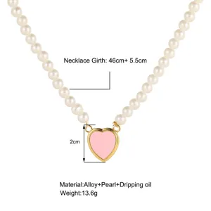 Détail d'un collier en perles avec pendentif cœur rose, détails du matériau.