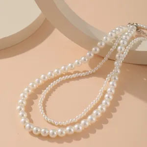 Gros plan d'un élégant collier double rang de perles fantaisie au fini blanc crème lisse