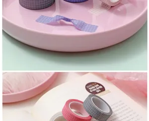 Detailed view of grid washi tape for journaling, featuring neat plaid patterns on pink tray.