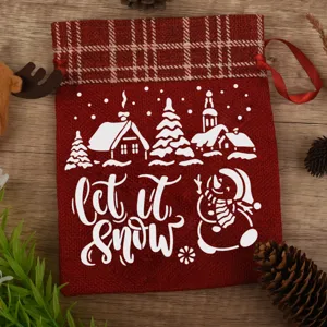 Red Christmas burlap gift bag with plaid top, drawstring pouch and festive winter snow print.