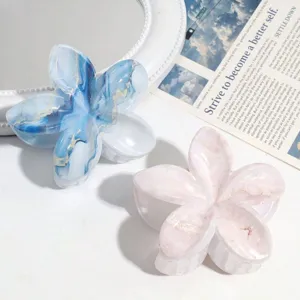Détail rapproché de pinces à cheveux florales aux motifs marbrés bleu et rose