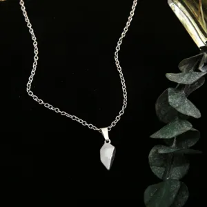 Detailed macro view of a silver magnetic heart pendant on a delicate link chain necklace