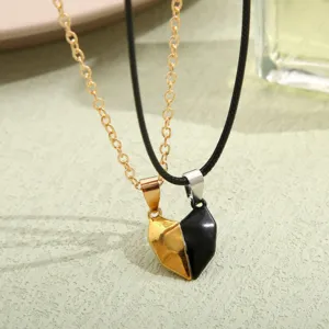 Close-up detail showing the magnetic connection of black and gold heart pendants for couples