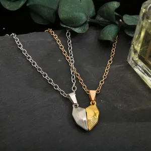 Macro detail of couple's magnetic heart pendants in gold and silver steel finish