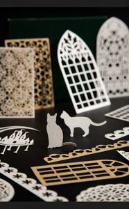 Primo piano dettagliato di materiali per bricolage in carta pizzo traforata con motivi fini.