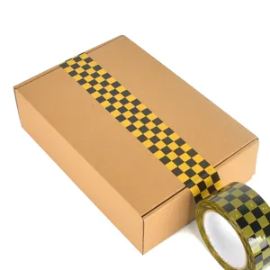 Ruban adhésif d'emballage à carreaux noir et jaune rétro avec boîte en carton pour colis.