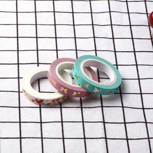 Juego de rollos de cinta washi decorativa con patrones de lazos dorados para manualidades.
