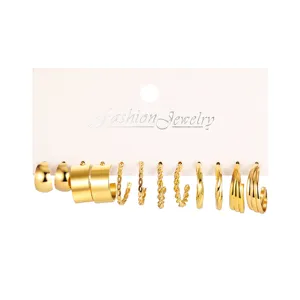 Detailed view showing a variety 6-pair set of gold C-shaped and chain hoop earrings.