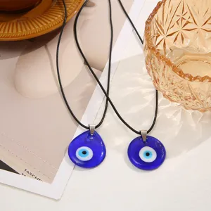 Macro detail of teardrop and round blue Evil Eye necklace pendants with black cords
