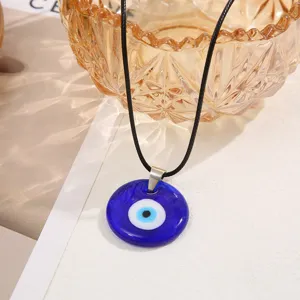 Detailed close-up of a blue Turkish evil eye glass pendant on minimalist black cord