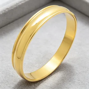 Vue détaillée d'un bracelet jonc large en acier titane doré à double rainure et finition polie.