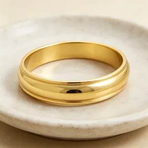 Vue détaillée d'un jonc large en acier titane doré à double rainure, bracelet élégant et lissé.